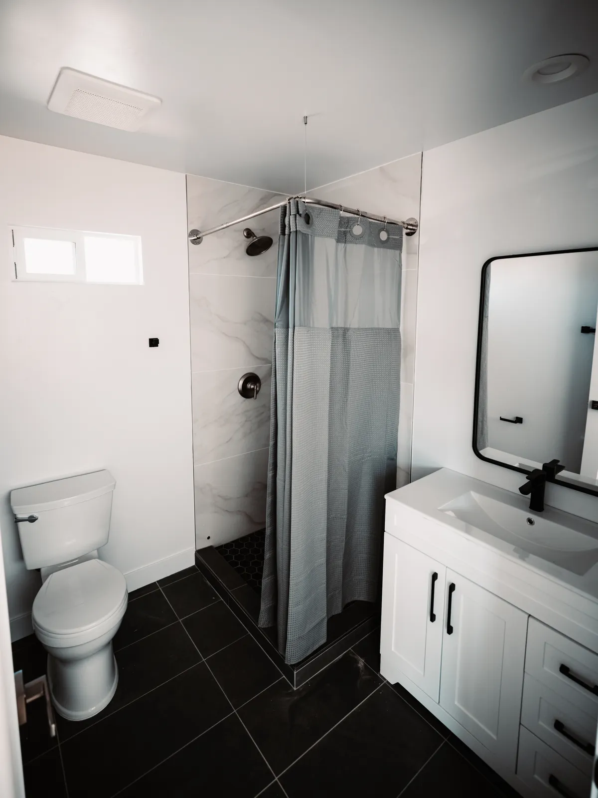 Bathroom with dark tile floor and black fixtures