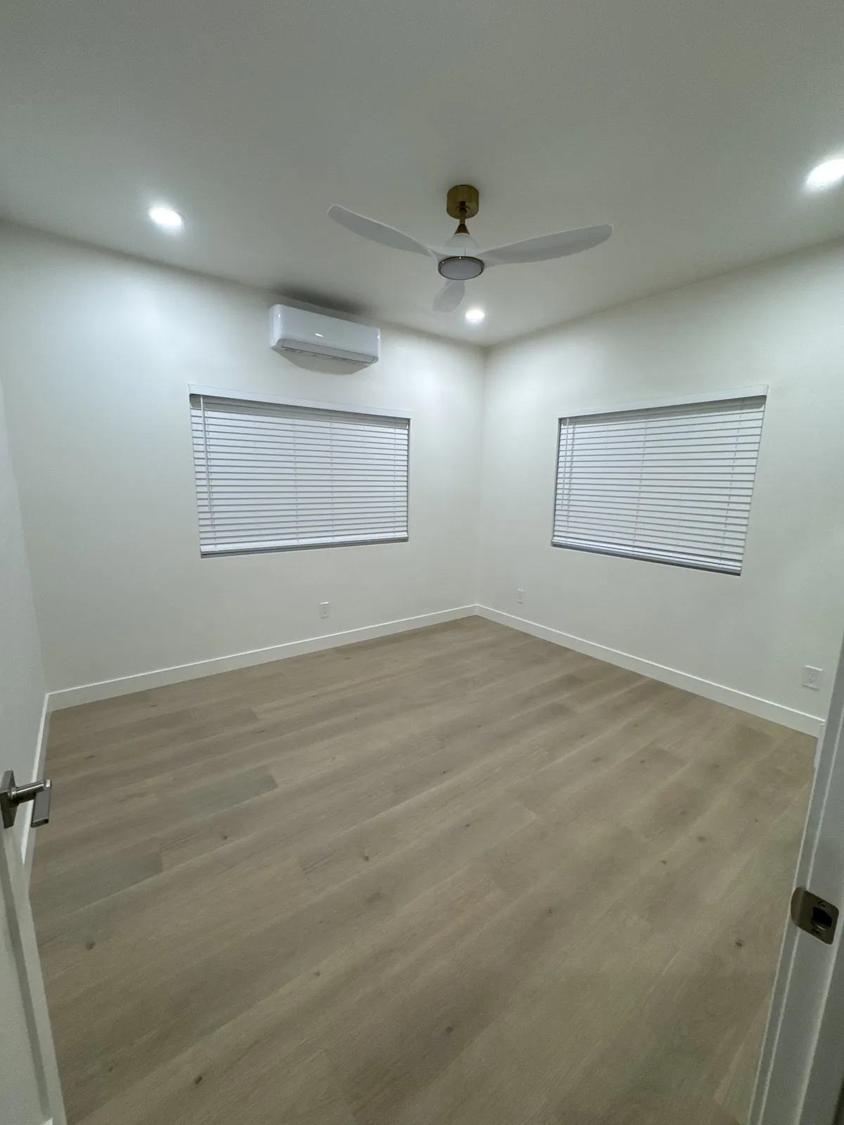 Finished bedroom with ceiling fan and new flooring