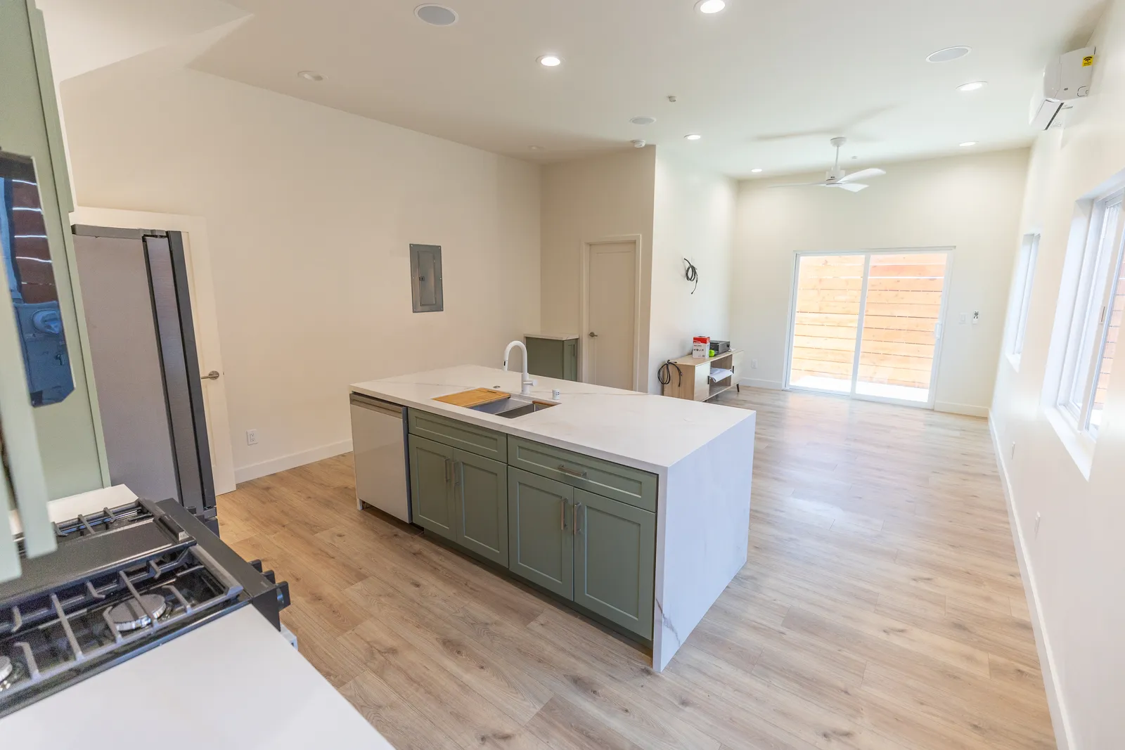 Kitchen island and sage cabinetry in an open plan
